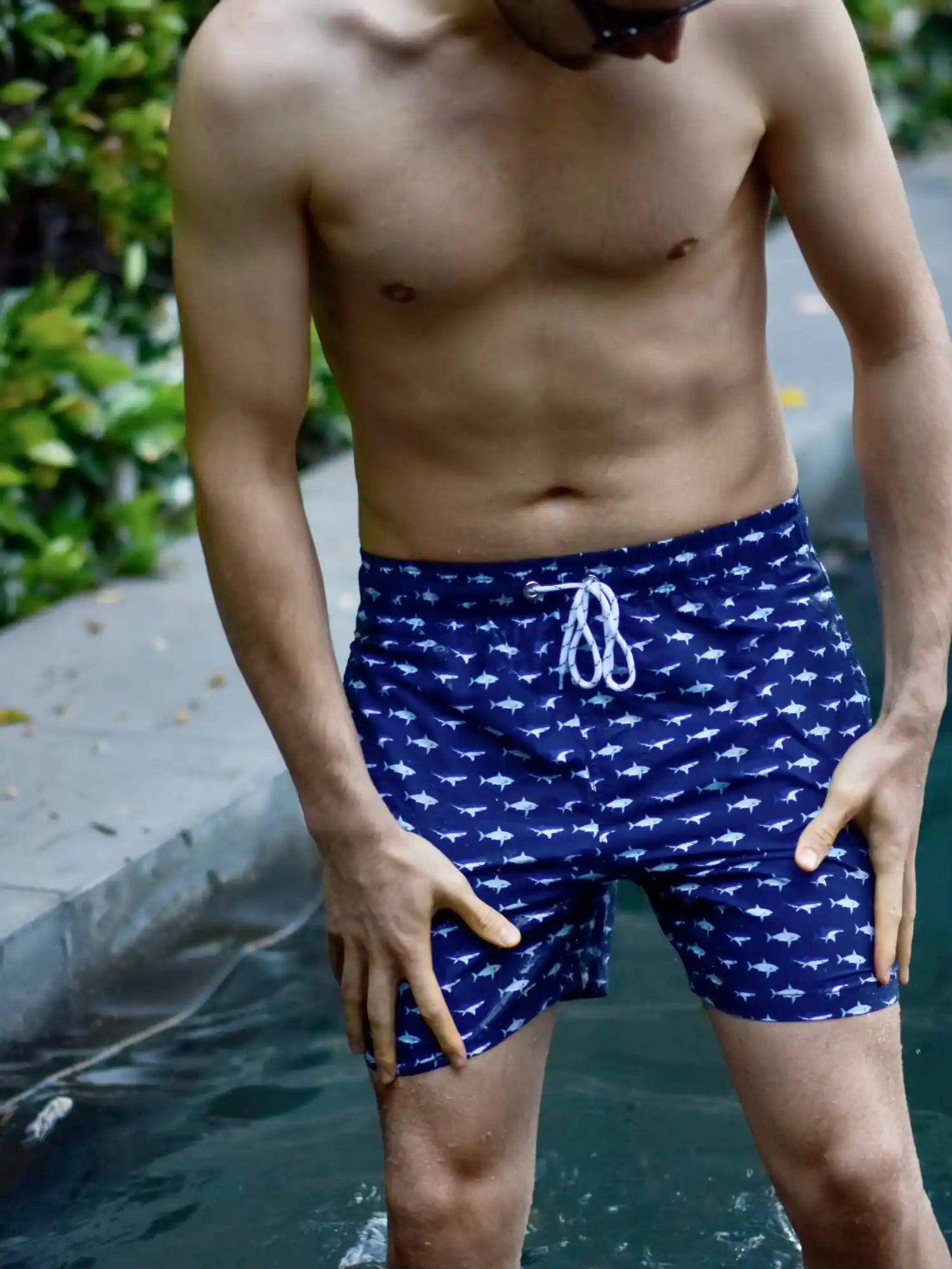 Navy blue swim trunks with a white fish pattern and drawstring waist.